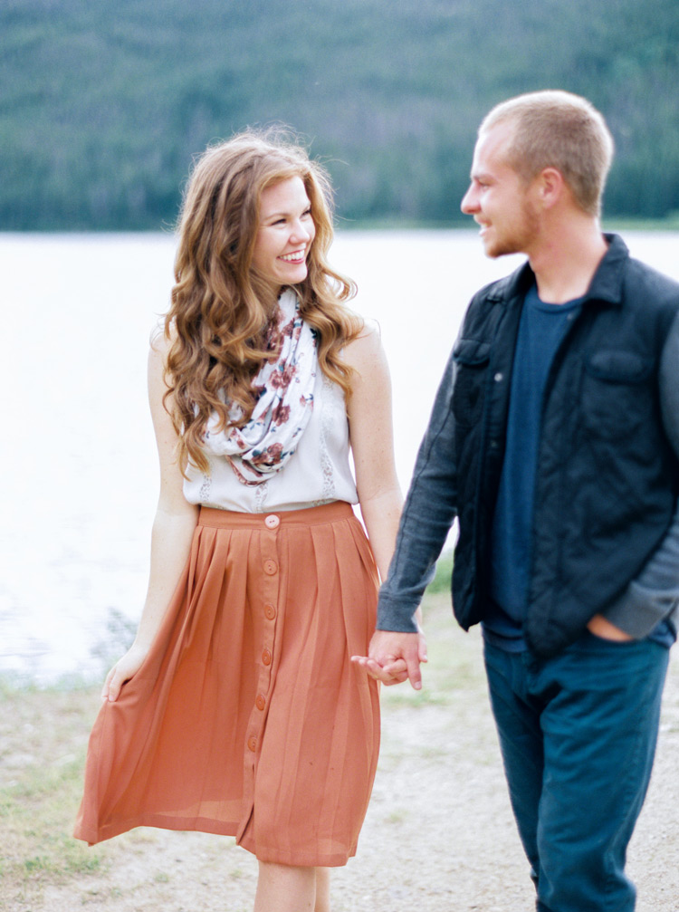Couple walking hand in hand near Colorado lakefront