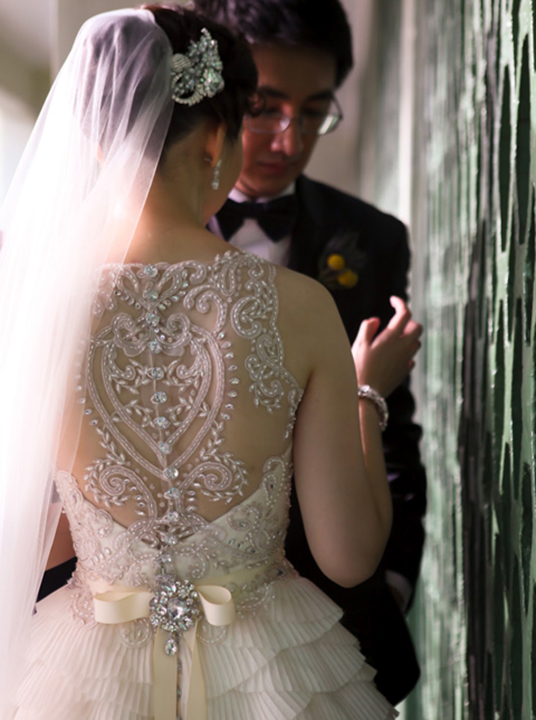 Lace back wedding dress with beaded and crystal detailing. Ruffled train and bow tied back. 