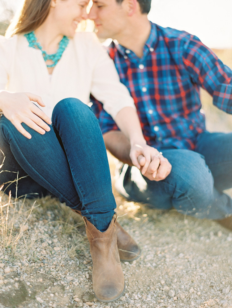 Holding hands and nuzzling -- sweet outdoor engagement shoot. Boots & jeans.