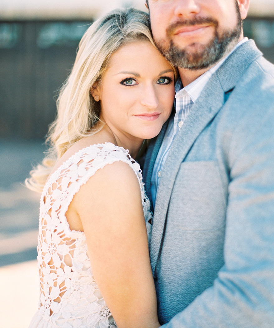 Gorgeous blonde bride-to-be in a lacy crocheted dress, groom-to-be in a gray sport coat.