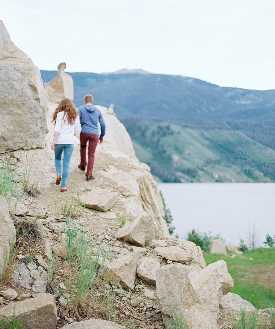 Engaged couple hiking mountainside in Rocky, Colorado shoot