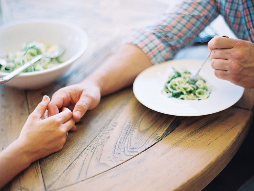 Holding hands and eating together. Romance at home! Zucchini pasta.