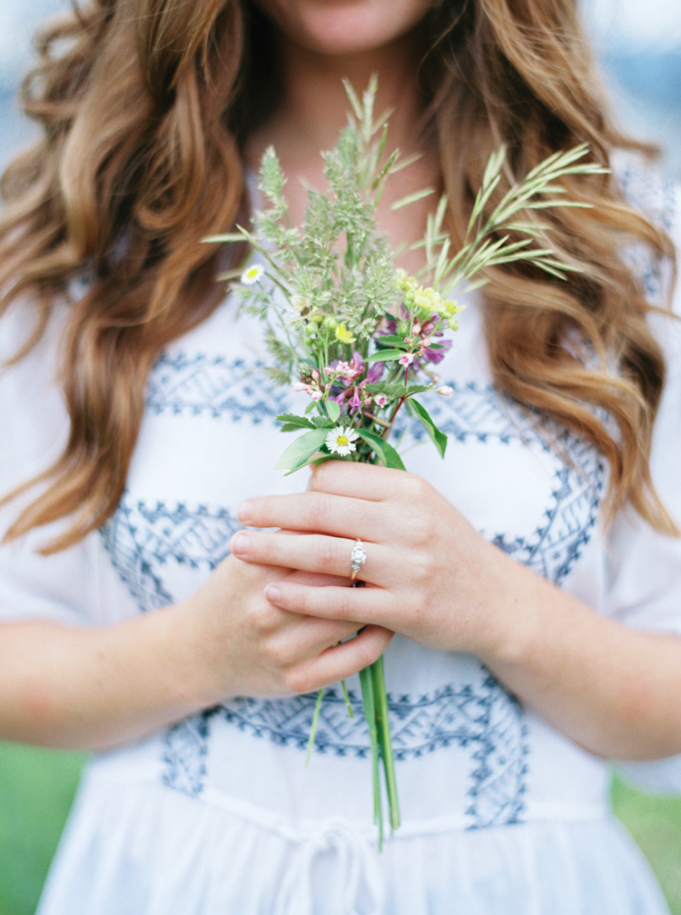 Bride holding wildflowers in Colorado green meadows session