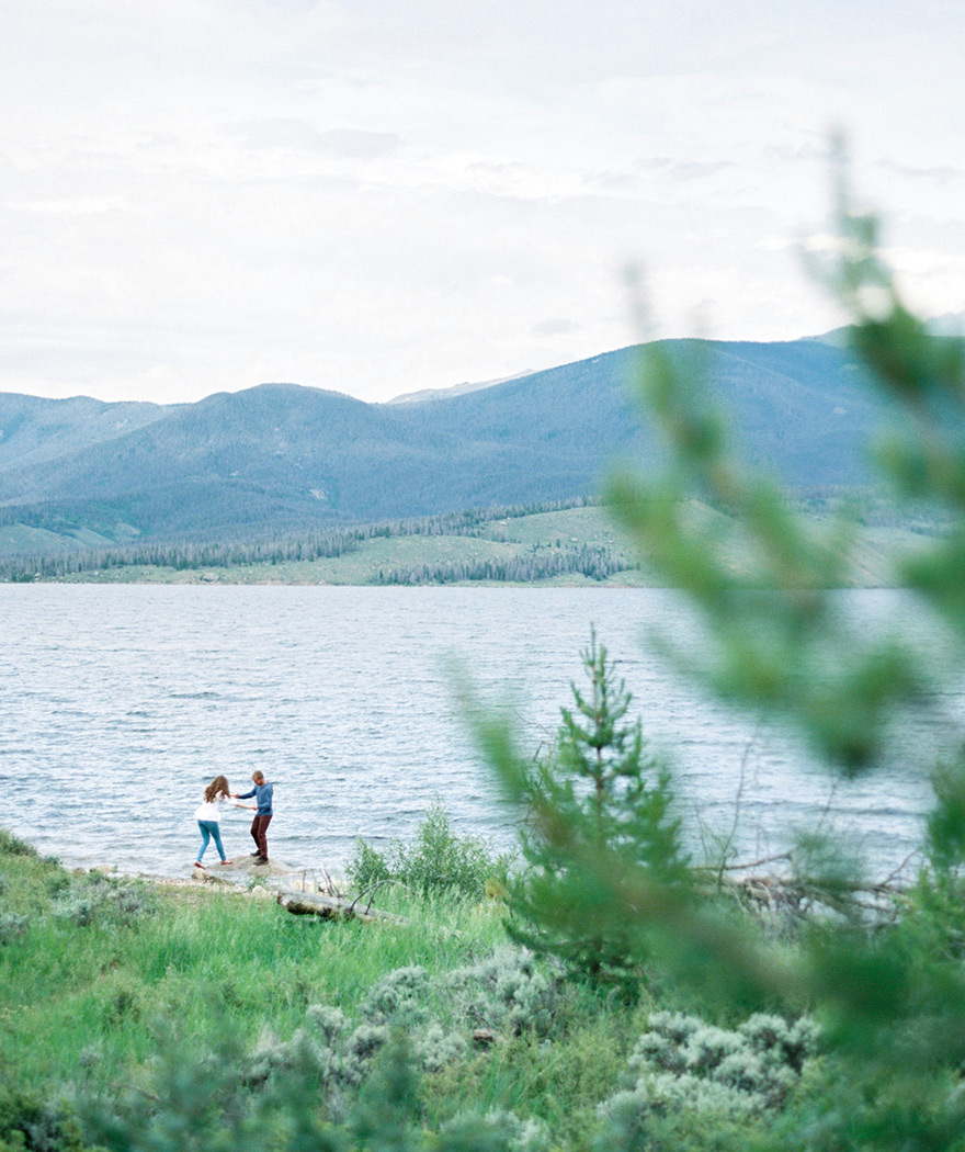 Organic moment together, holding hands at the lake. Colorado lakeside engagement photos. 