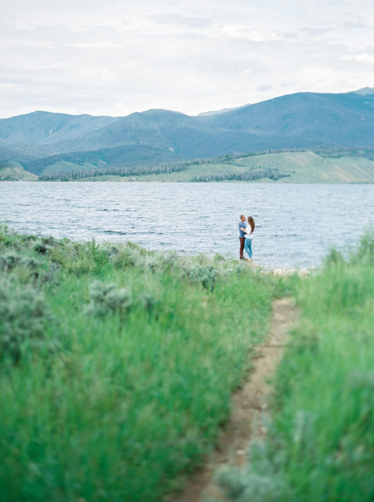 Loving couple share a quiet moment at the lake. Outdoor Colorado engagement photos. 