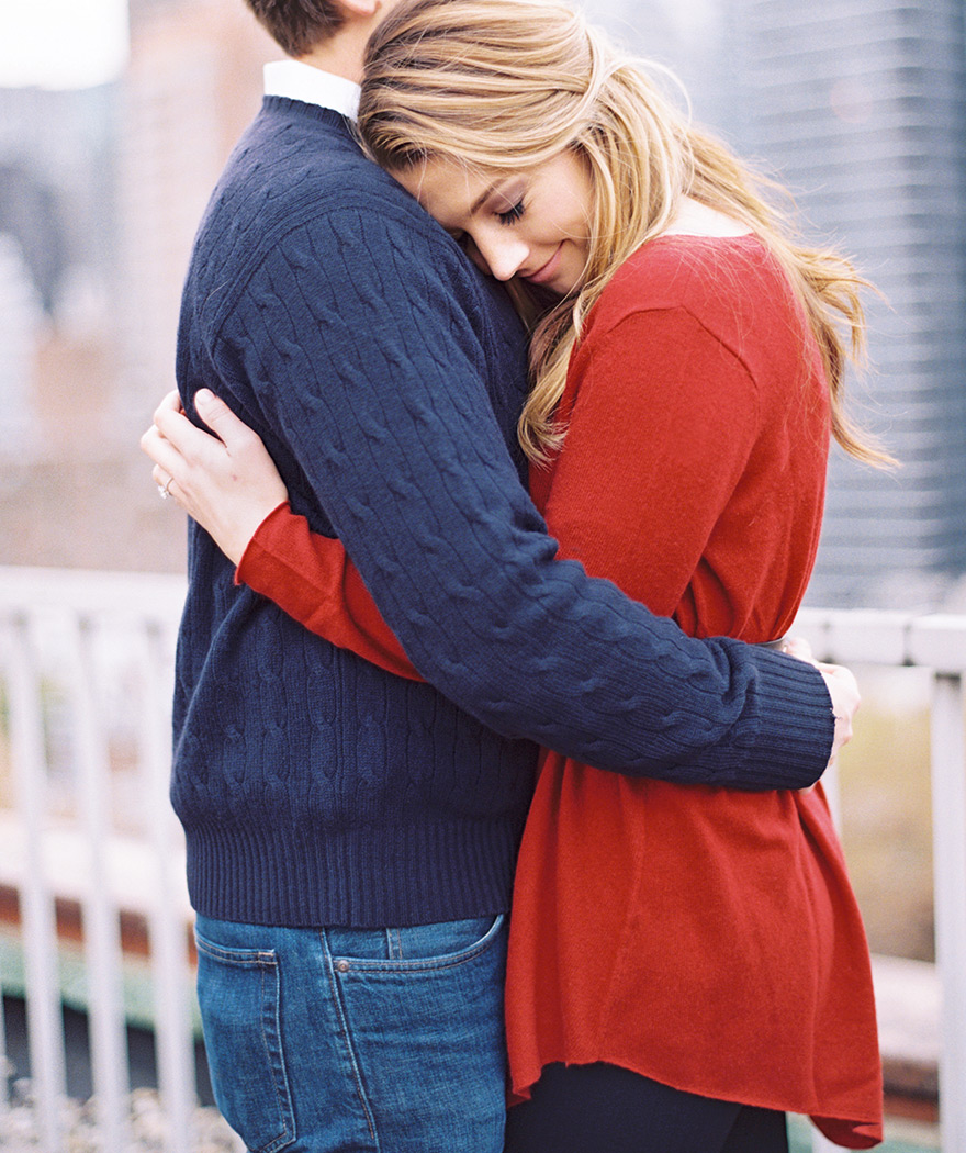 Loving hug with her head on his shoulder. Natural engagement shoot pose