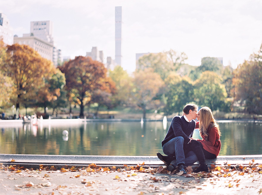 Seated couple kiss outdoors in NYC. Autumn in the city.
