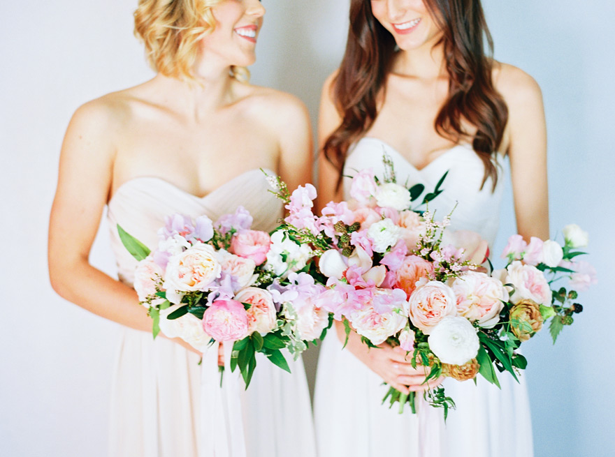 Pale, strapless gowns and soft, full bouquets of peonies, roses, sweet pea. Wedding flowers.