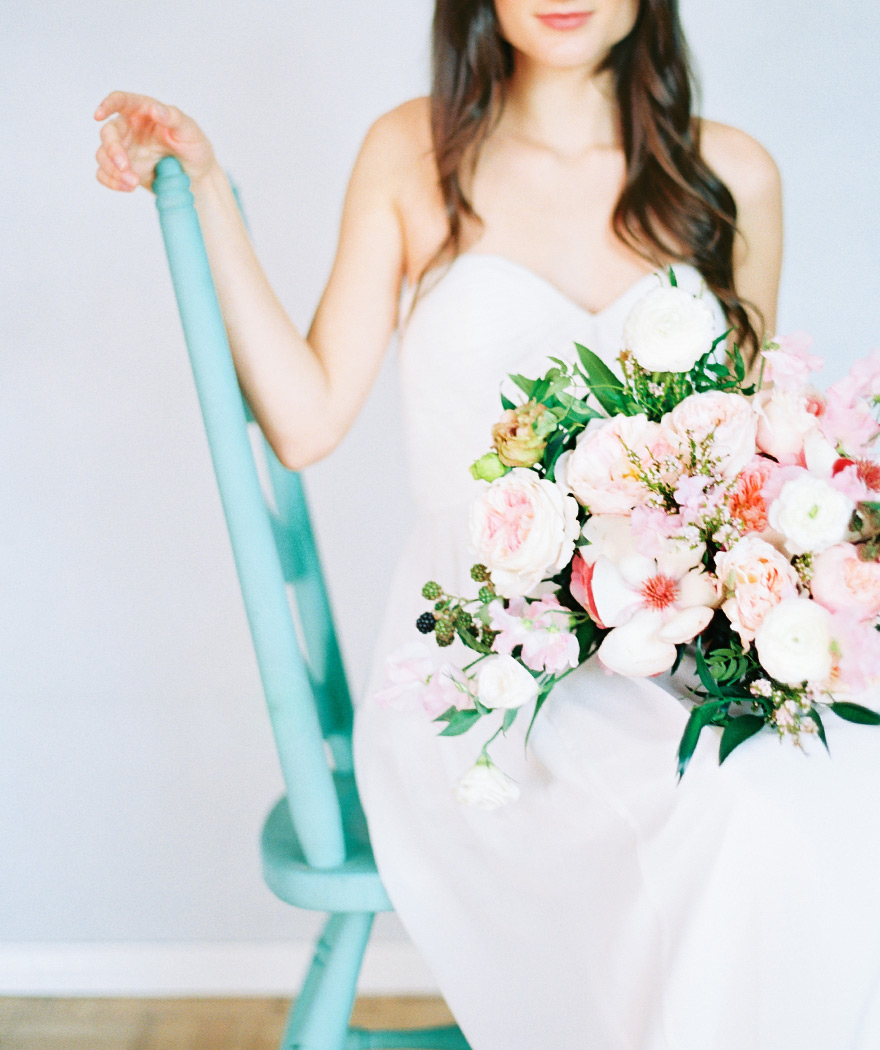A strapless gown and a soft, full bouquet of peonies, ranunculus, blackberry. Wedding flowers.