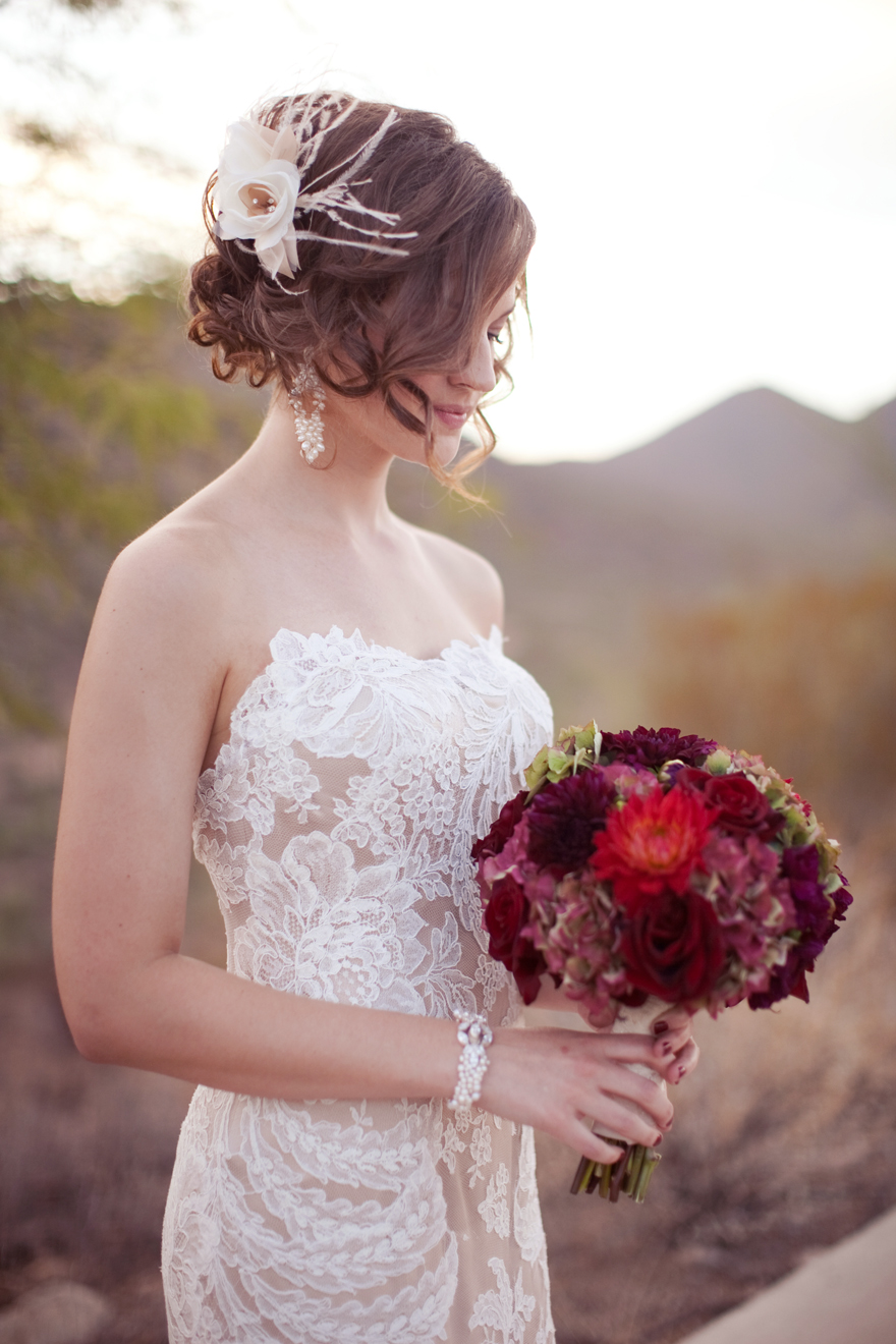 Lace wedding dress and bride holding deep, elegant bouquet arrangement 