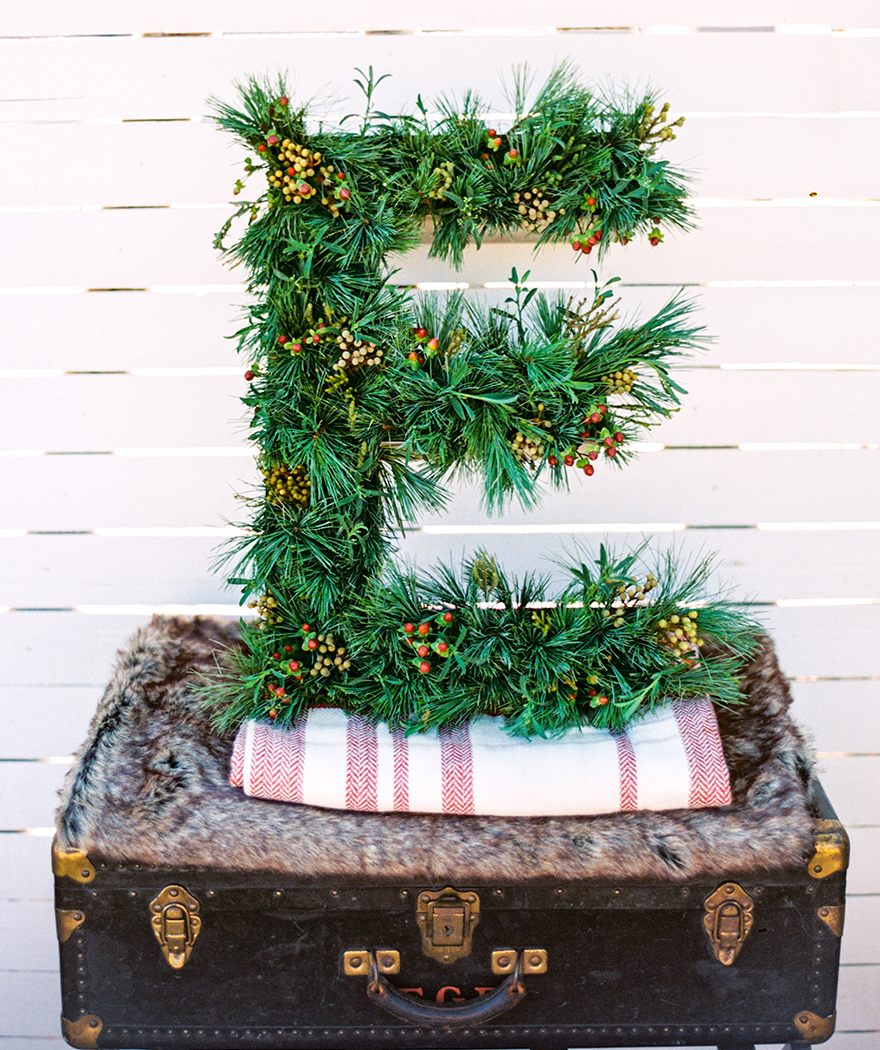 Hollow metal letter E filled with greenery.