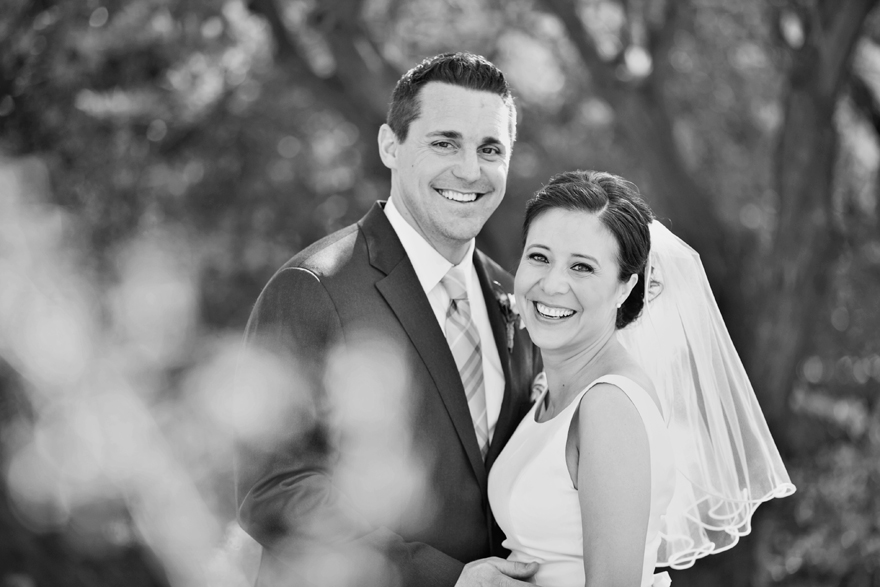 Black & white portrait of a laughing bride & groom on their wedding day.
