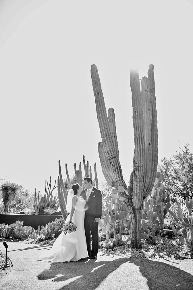 Bride & groom share a kiss surrounded by cacti. Desert Botanical Garden.