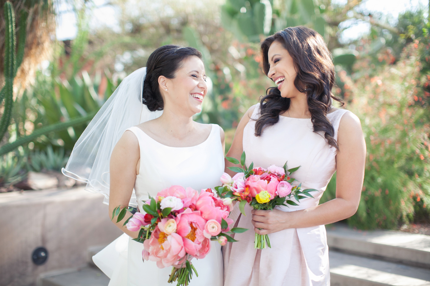 Laughter and joy between the bride & her maid of honor. Pretty pink flowers.
