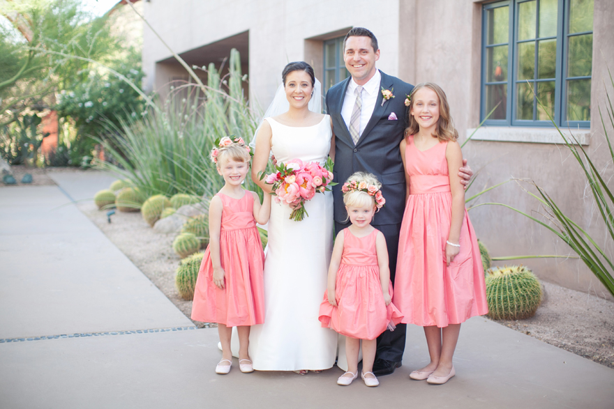 Bride & groom surrounded by their bridal party of young girls in pink.