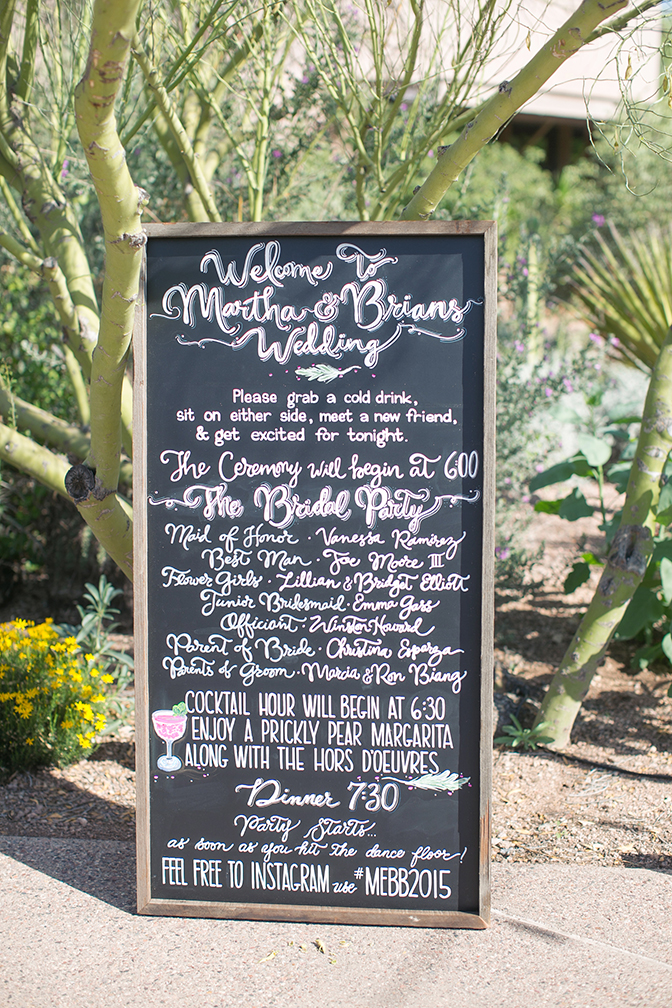 Hand-lettered chalkboard sign a stylish outdoor wedding.