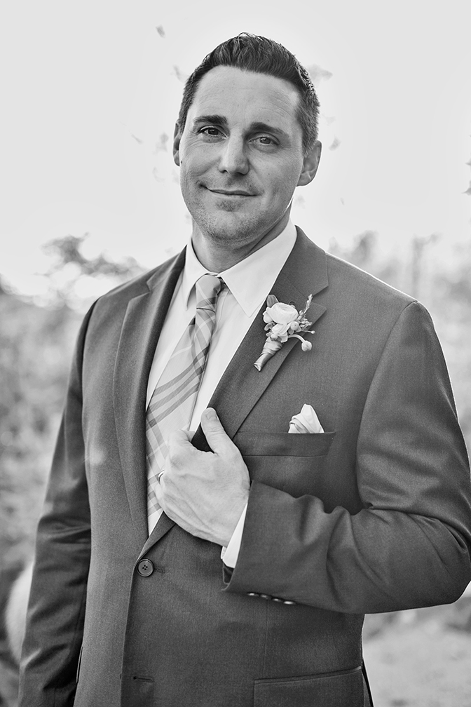 Black & white portrait of a handsome, smiling groom.