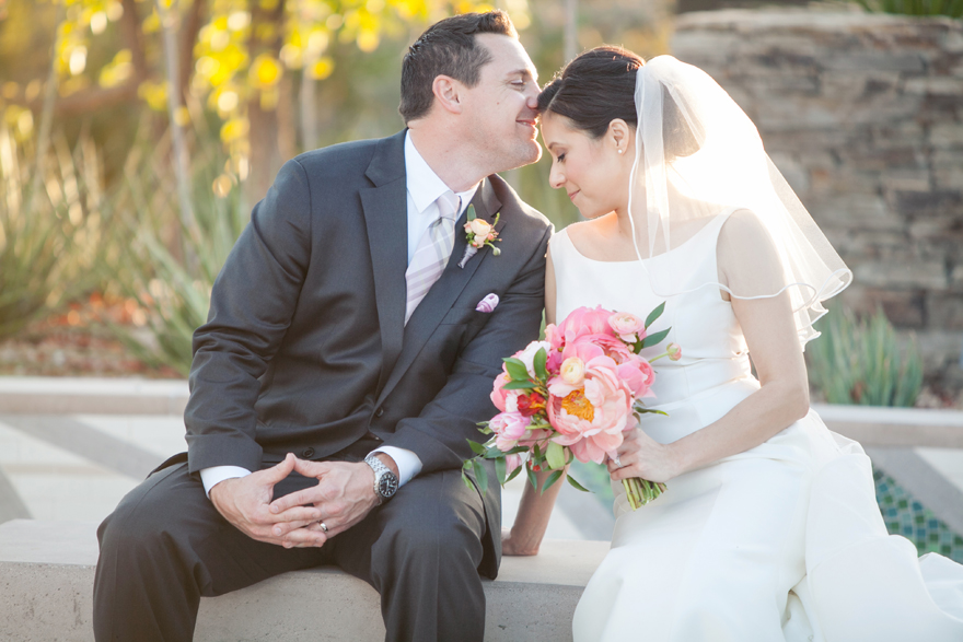 Groom presses a kiss to his bride's forehead. Desert Botanical Garden.