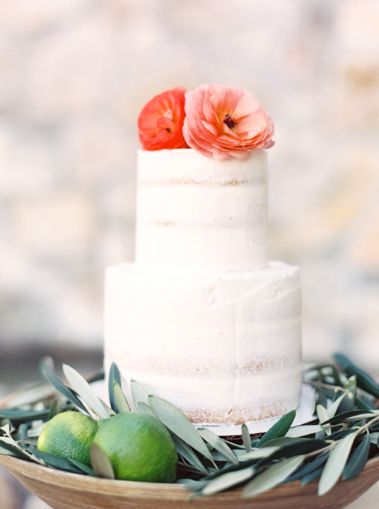 Beautiful and simple two-tiered wedding cake with coral flowers as accents. Wedding cake ideas. 