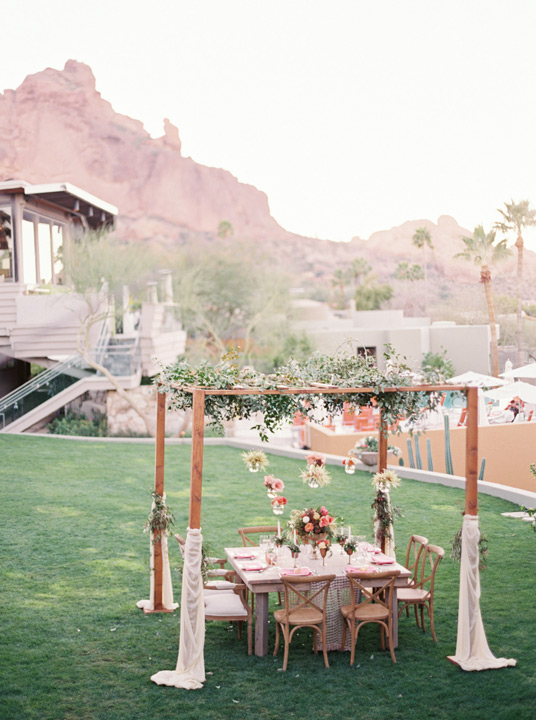 Wedding reception table set up inspiration with floral pergola and hanging flowers & desert plants. 