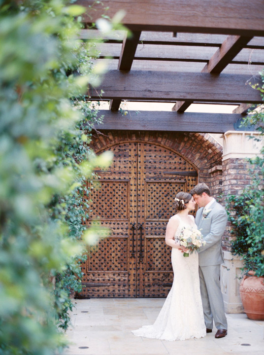 Bride in gorgeous lace wedding dress as her groom brushes her nose sweetly. Wedding bouquet ideas. 