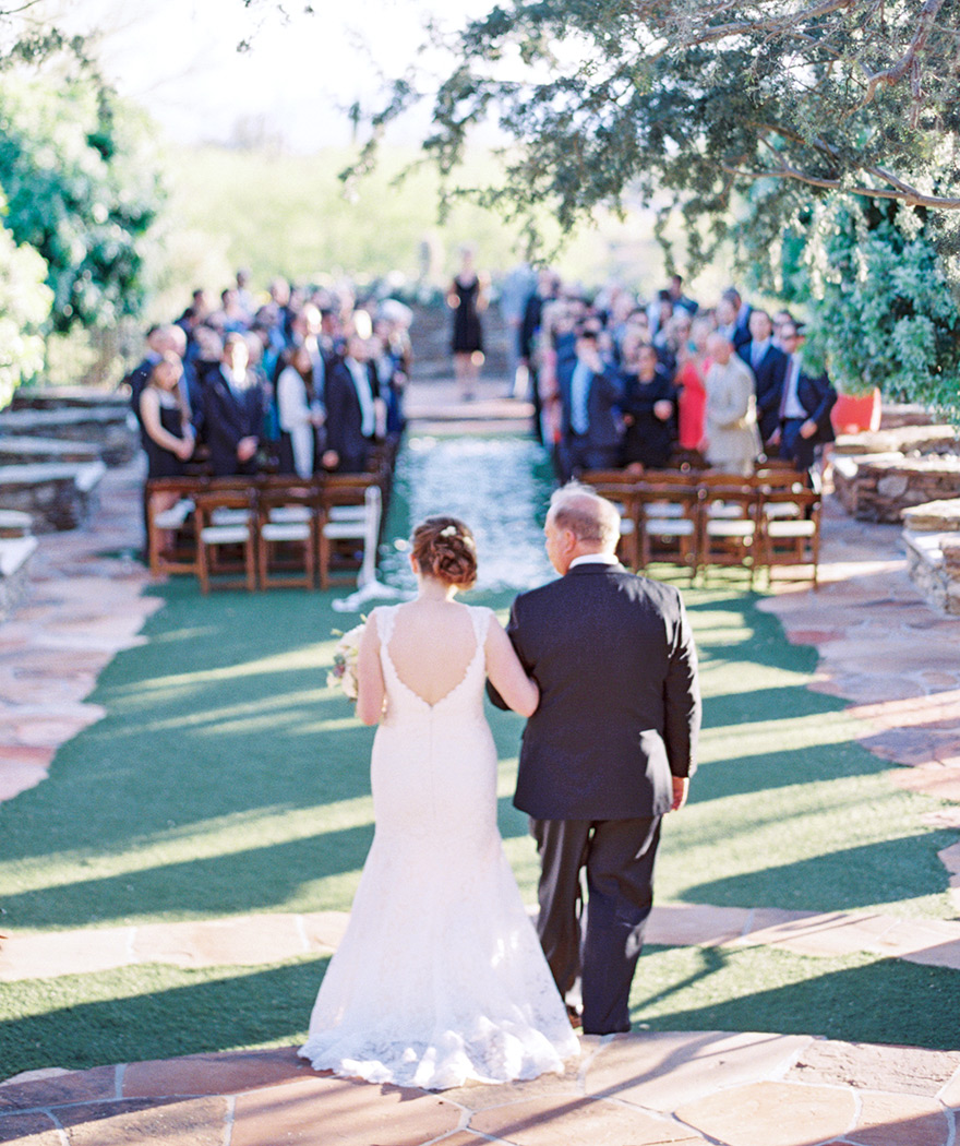 Father of the bride walks his daughter down the isle at wedding.  Venue is Sassi in Scottsdale, AZ. 