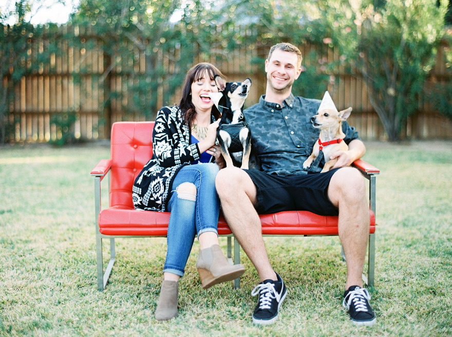 Family fun with two dogs barking outdoor. Posed in unique red couch.