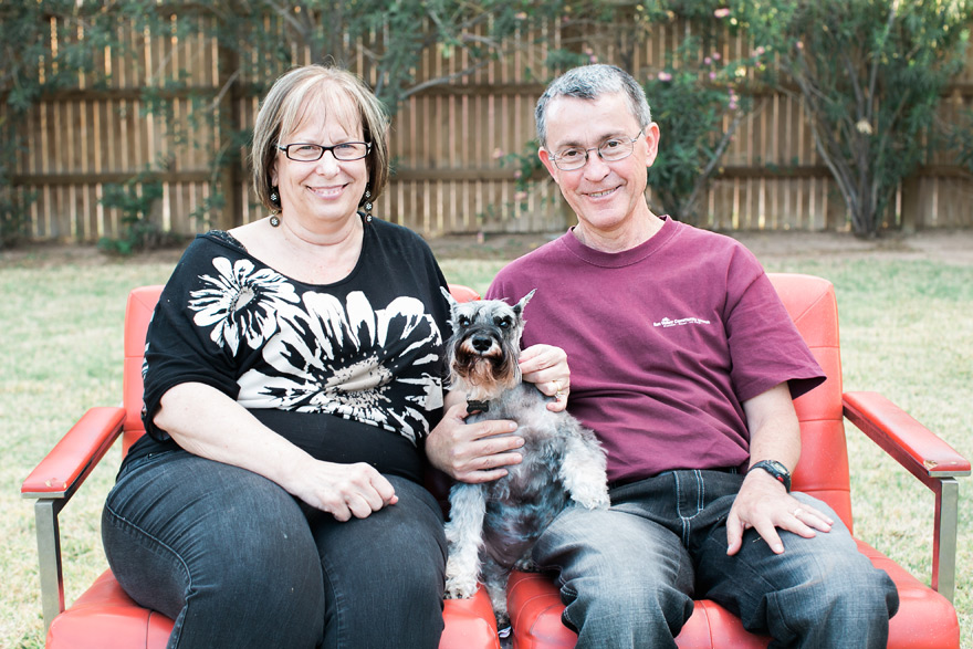 Couple smiling in outdoor play date with puppy dog on sofa.