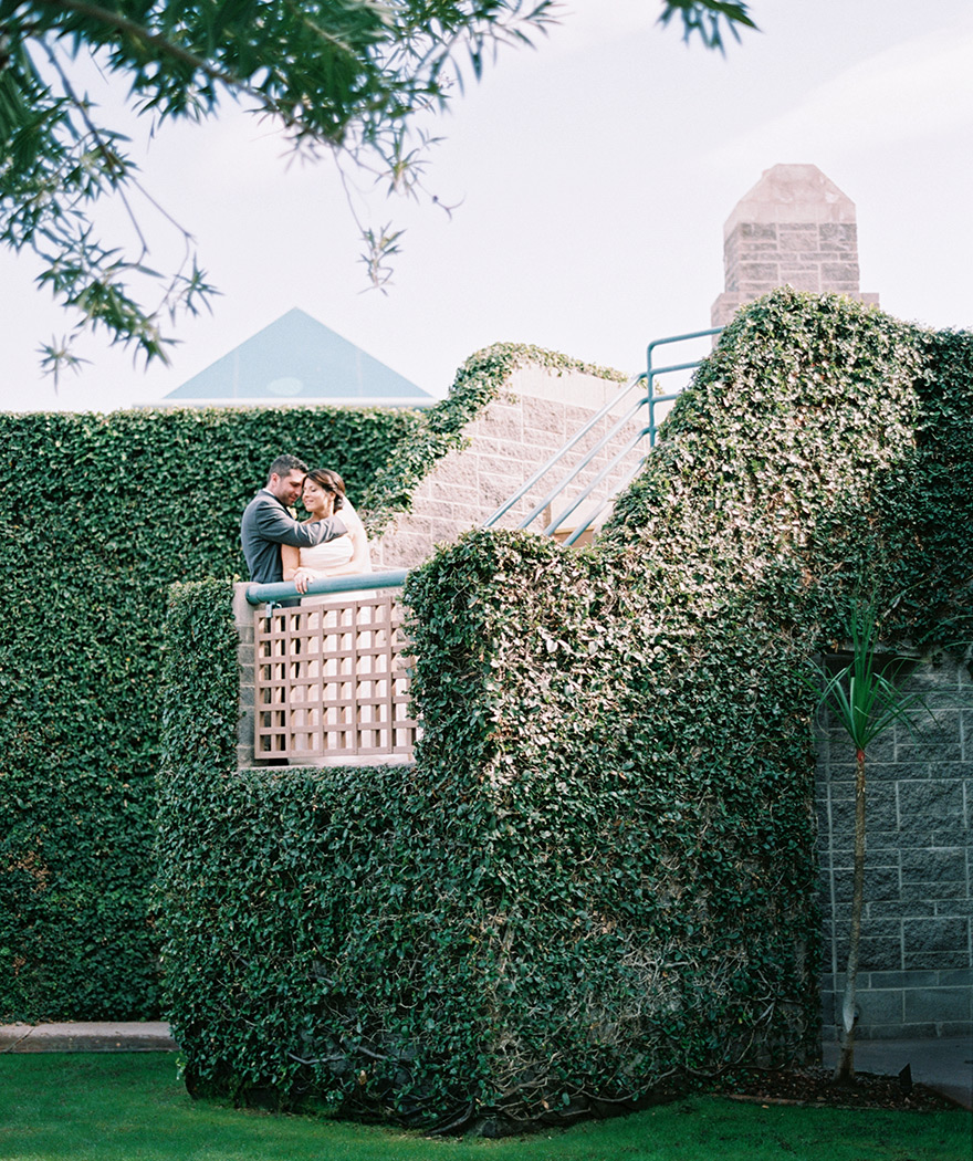 bride & groom embrace on an ivy-covered stairway