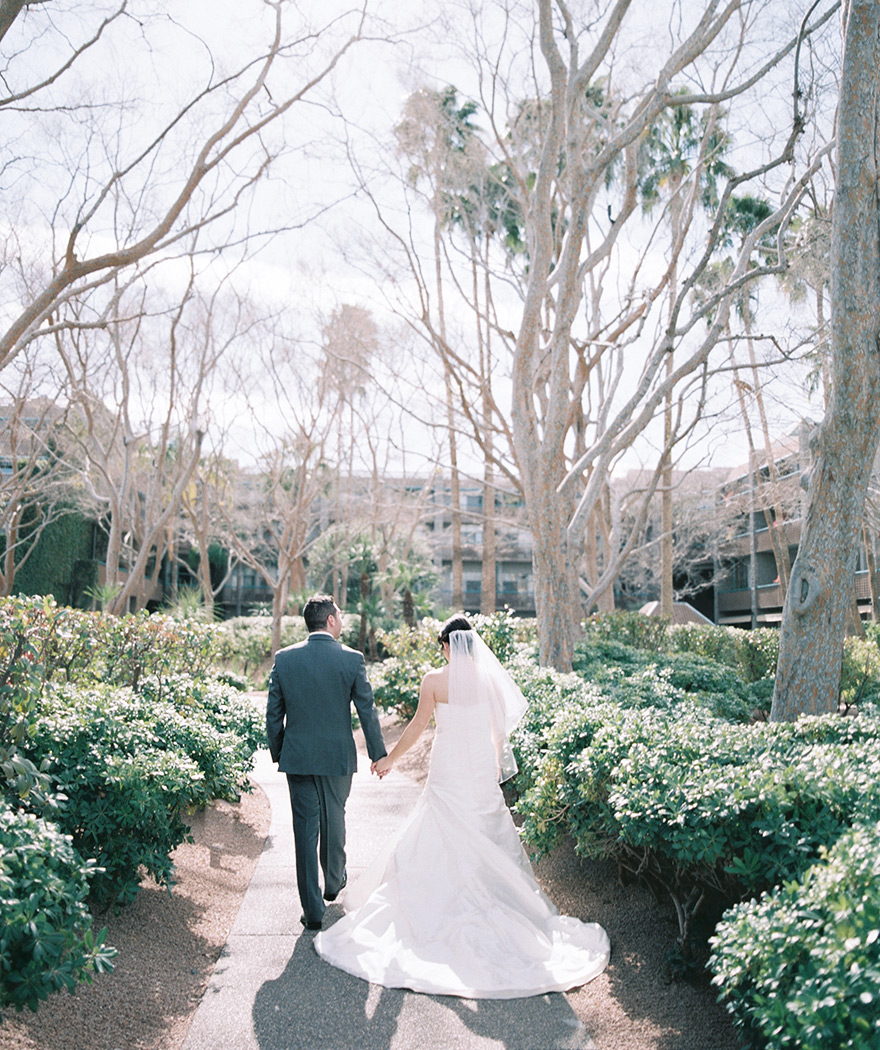 happy bride & groom walk hand-in-hand at Hyatt Scottsdale