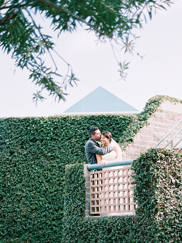 bride & groom embrace on an ivy-covered stairway