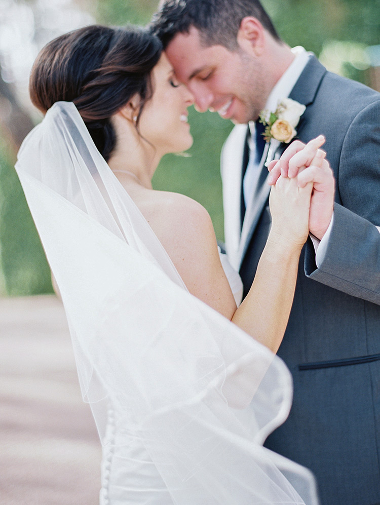 joyous bride & groom clasp hands