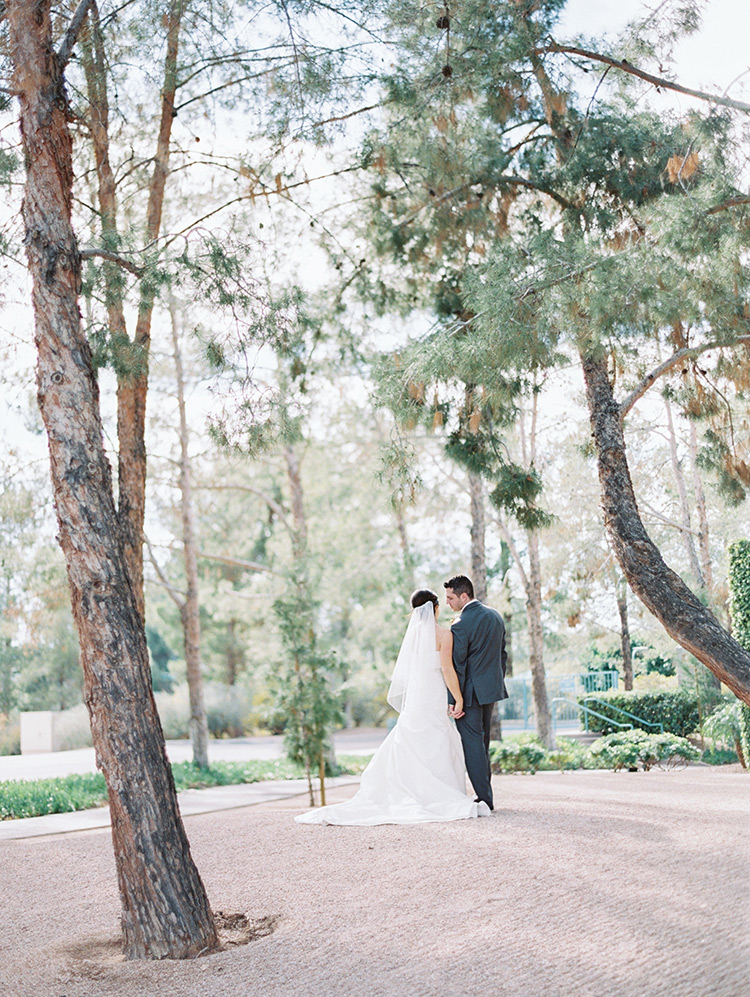 happy bride & groom walk hand-in-hand at Hyatt Scottsdale