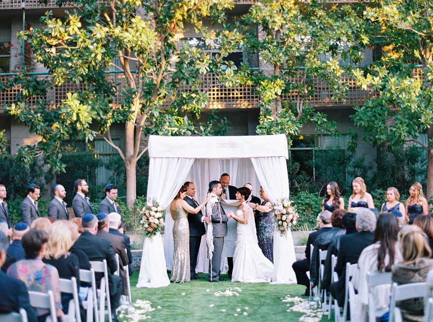 tallit wrapped around the bride & groom under the chuppah