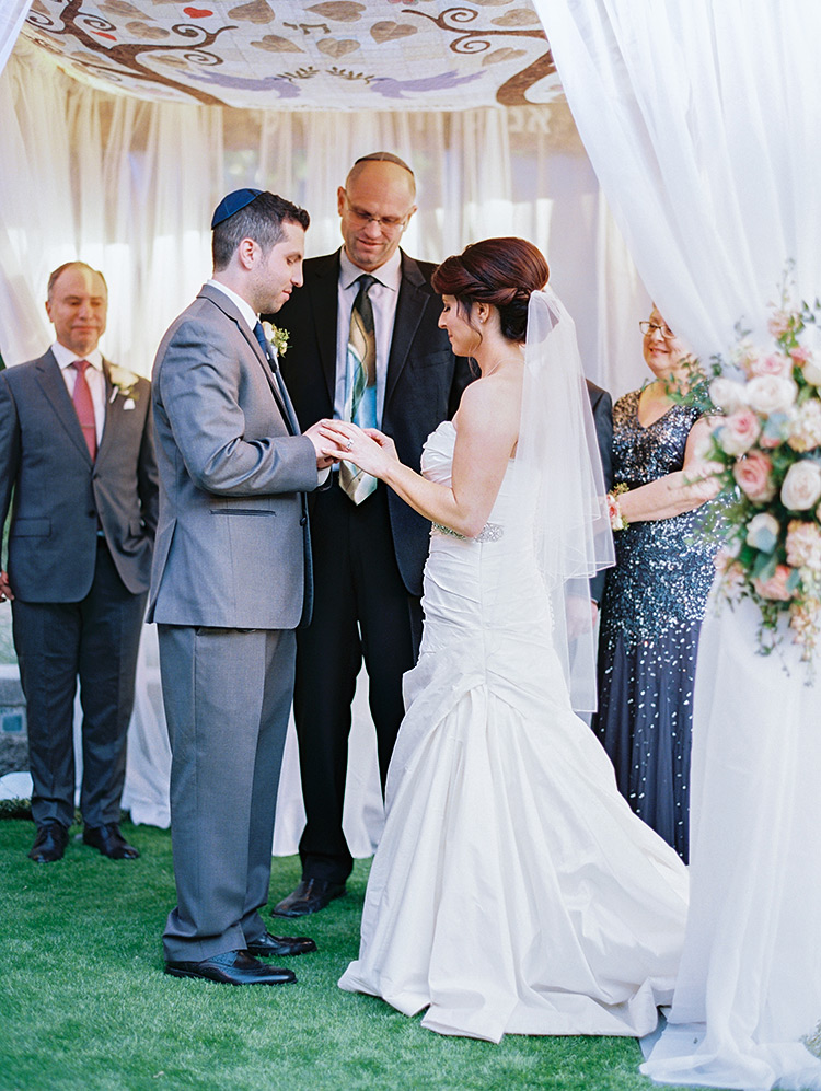 bride & groom exchange rings under the chuppah