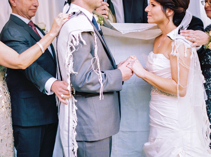bride & groom surrounded by family & wrapped in the tallit