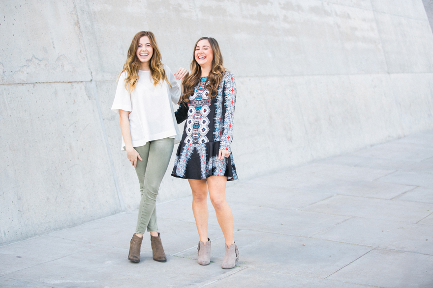 Fashionable girls laughing by concrete wall session.