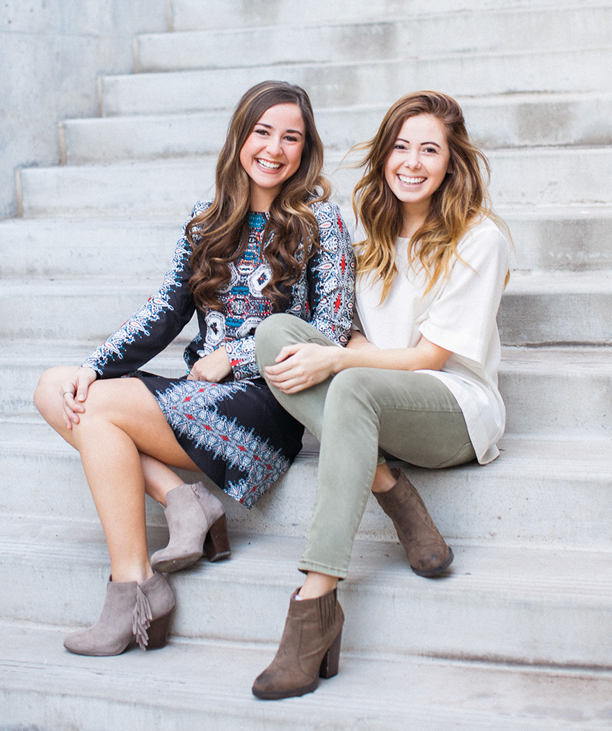 Happy and chic modern girls sitting on steps in fashionable boots photo shoot. 