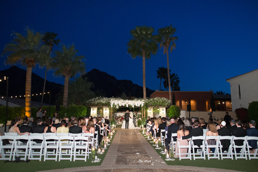 sunset ceremony beneath a flower-decked chuppah