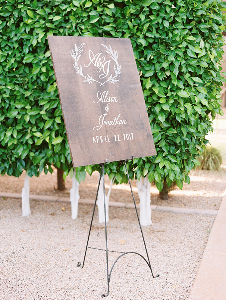unique wooden sign at an outdoor wedding