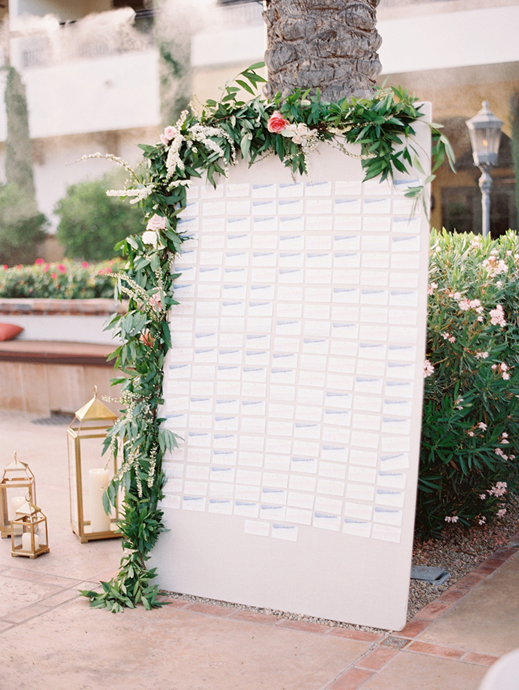 escort card display draped with a flowering garland