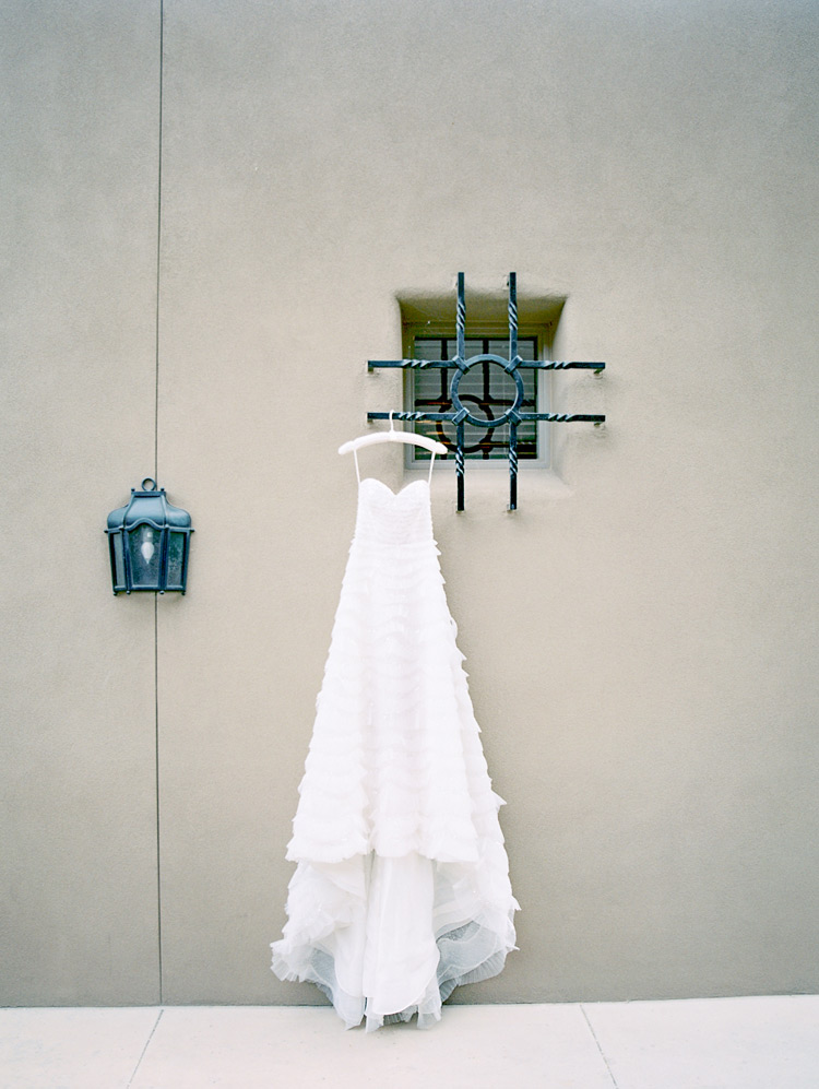 Wedding gown hanging outdoors. Long strapless A-line dress with ruffles.