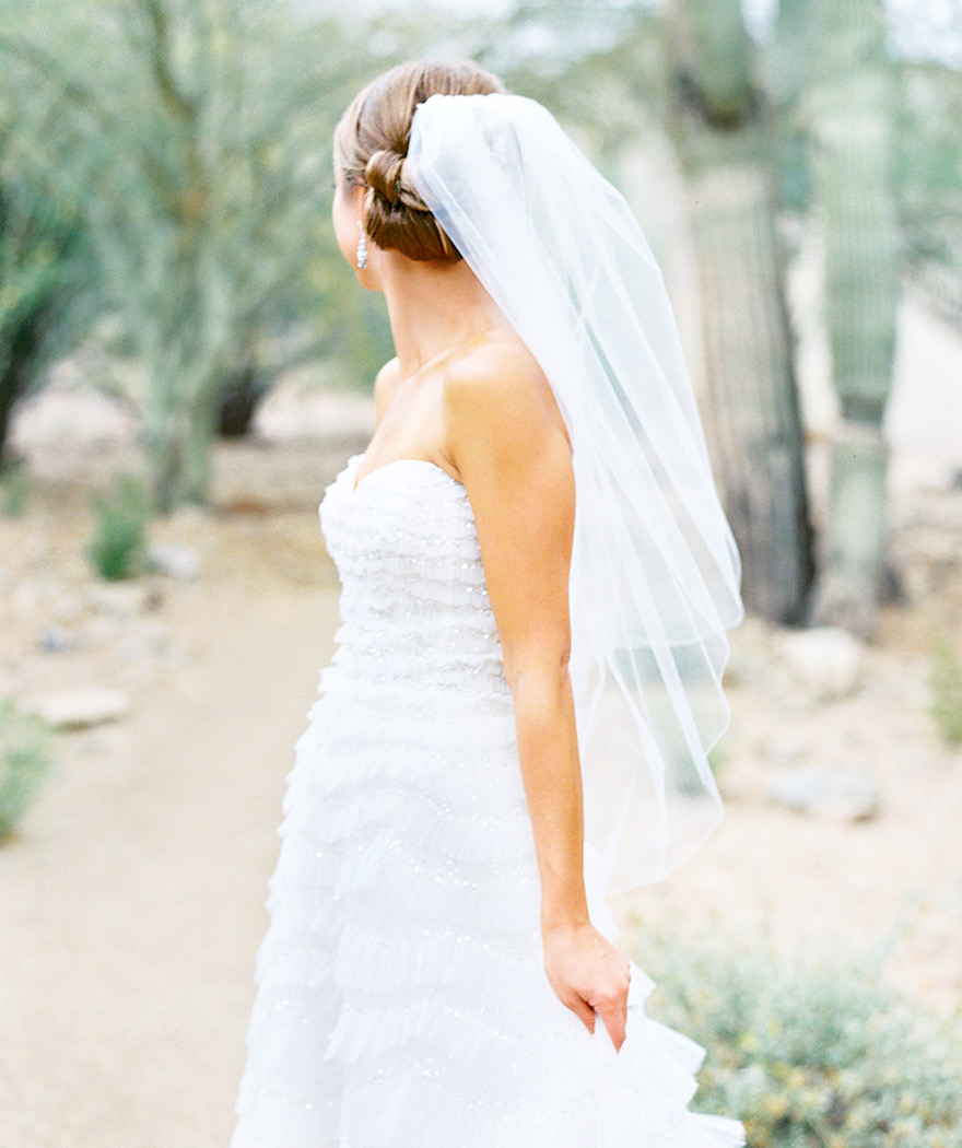 Sunlit bride in a long, ruffled gown. Desert wedding