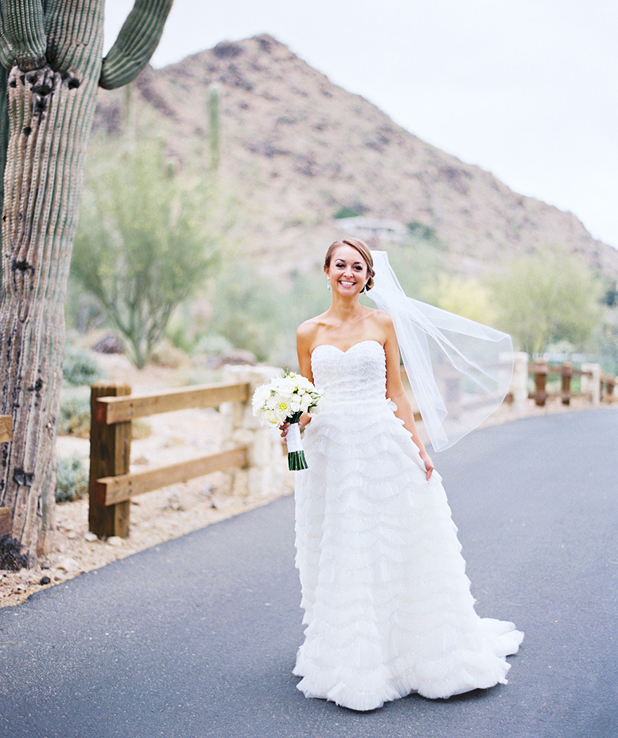 Happy bride in her sparkling, ruffled gown. White bouquet