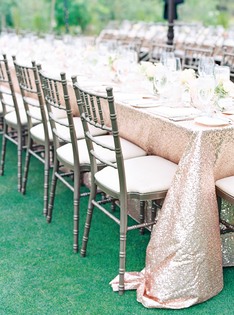 Elegant outdoor wedding reception with long tables and sequined linens 
