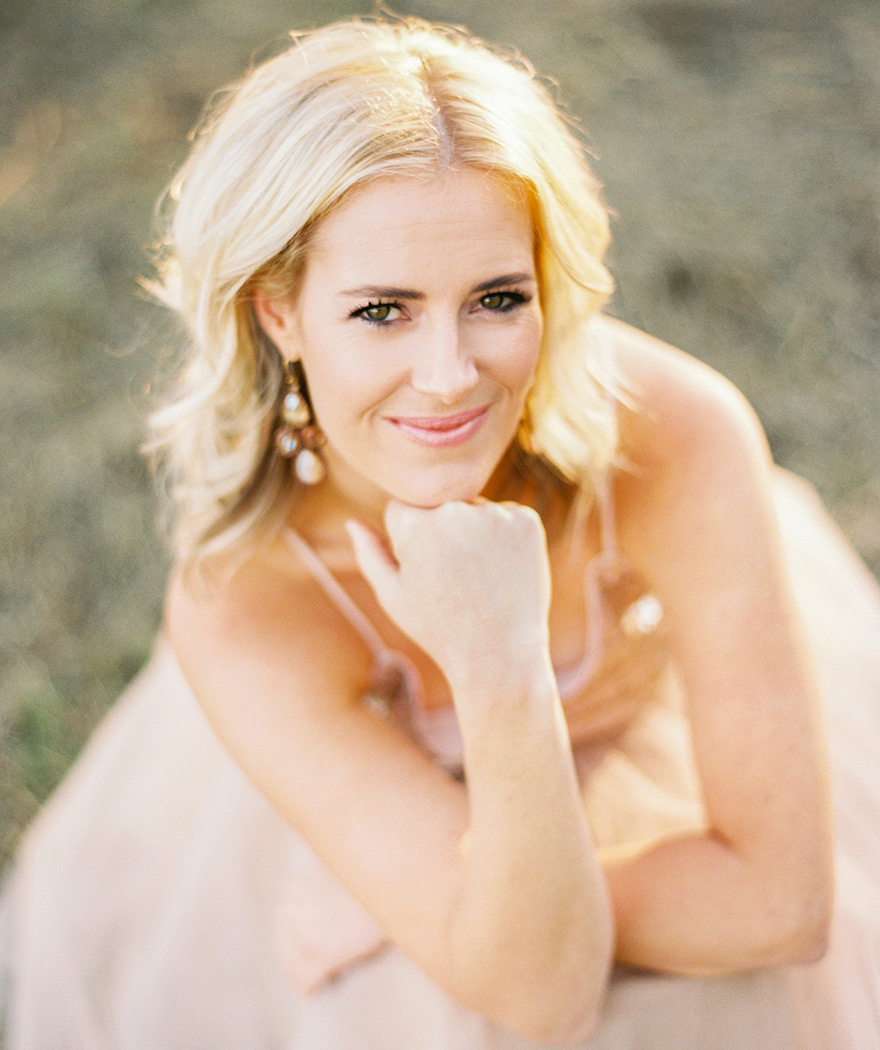 Soft smile from blonde portrait kneeling down. Outdoor blush session. 