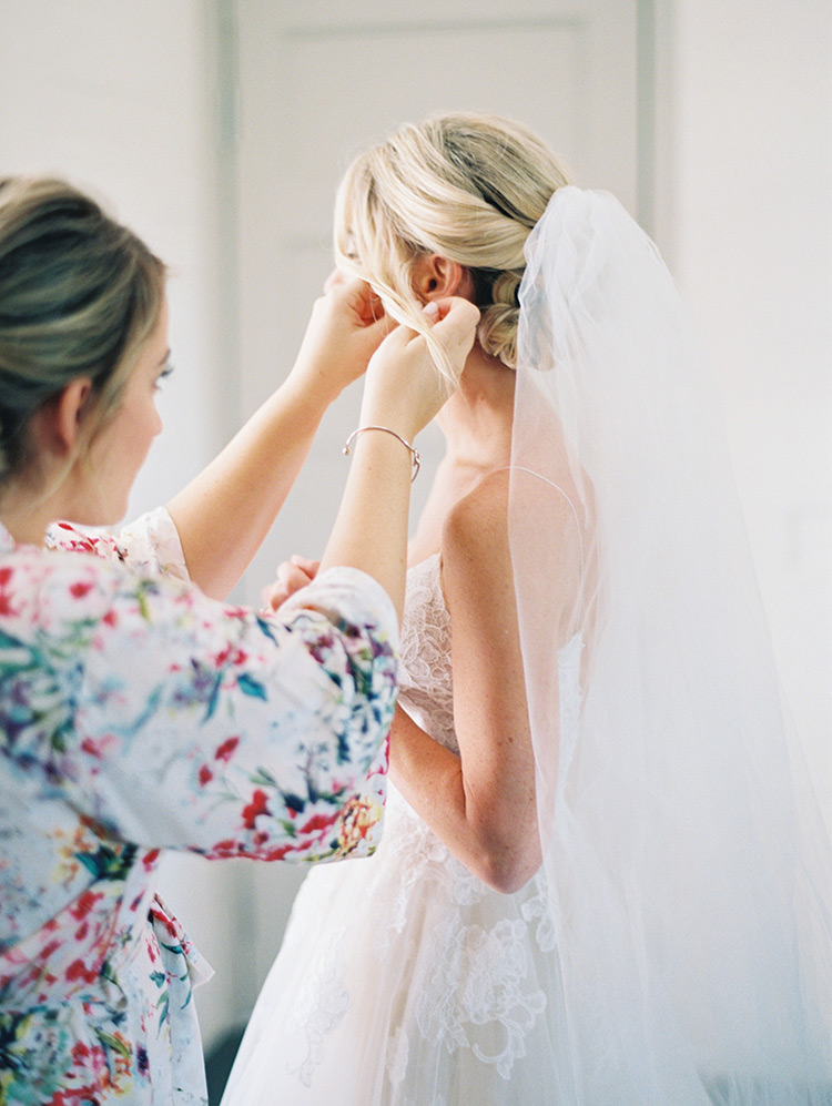 bridesmaid helps with the finishing touches