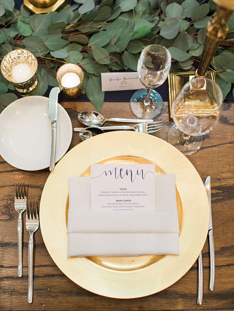 modern wedding reception with greenery and gold accents