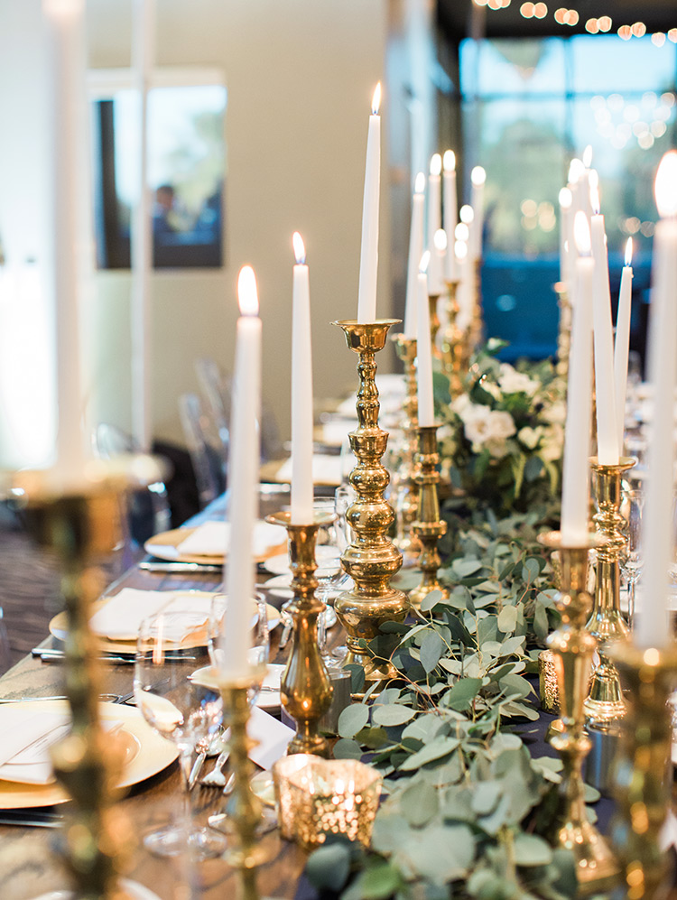 candlelit wedding reception with greenery and gold accents