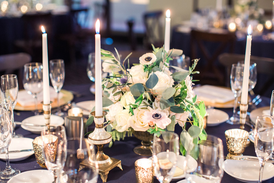 candlelit wedding reception with greenery and gold accents